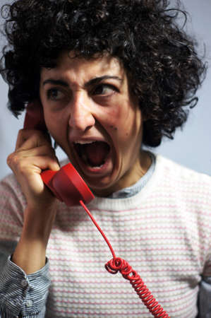 Woman is going mad on the red phoneの写真素材