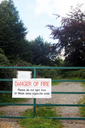 Warning sign on metal gate in woodlandの写真素材