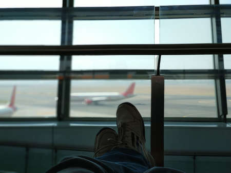 Traveler relaxing while wait to flight departure time at the airport, delay flight, travel concept.の写真素材