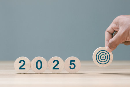 2025 business goals. Wooden block with 2025 word and target icon. set up objective target business cost and budget planning for new year concept.の写真素材