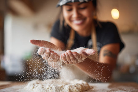Close up of young woman preparing dough for pizza in the kitchen.の素材