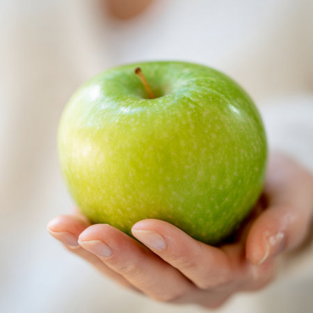 Closeup on green apple in woman's hand, shallow depth of fieldの素材