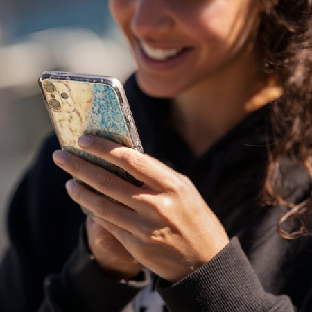 Close up of a young woman using mobile smart phone in the cityの素材