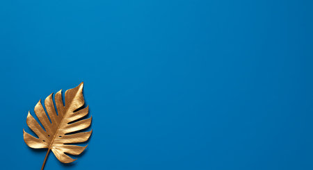 Gold leaf monstera on blue background. Minimal summer concept.の素材