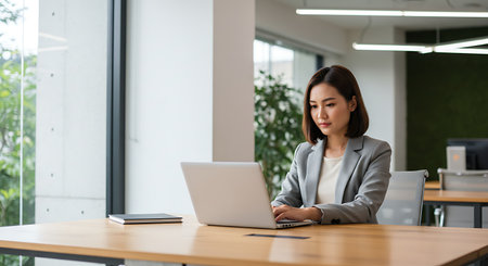 asian businesswoman using laptop computer in modern office. business and technology conceptの素材