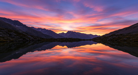 Sunset over a lake in New Zealand alps with reflection in waterの素材