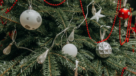 Decorated Christmas tree with silver and white ornaments.の素材