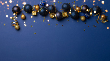Christmas or New Year blue background with golden and black baubles, confetti and lights. Copy space.の素材