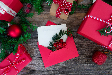 Christmas background with red gift boxes and christmas tree branches on wooden boardの素材