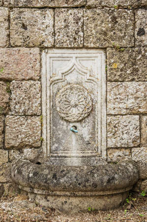 Fountain in the Wall of the Casstle on the Filerimos Hill in Rhodesの写真素材