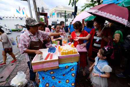 BANGKOK, THAILAND - AUGUST 17  Unidentified tourists buy orange juice in front Grand Palace, orange juice is good choice when weather high temperature at Bangkok on August 17, 2013 in Bangkok,Thailandのeditorial素材
