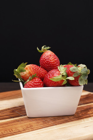 A group of fresh strawberries on a timber board の写真素材