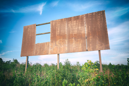 Outback rusted blank damaged and old sign in the long grass.の写真素材