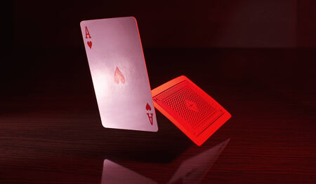 A pair of aces playing cards with a red tint. High contrast with dark background.