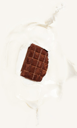 Dark chocolate splashed into fresh milk with white background.