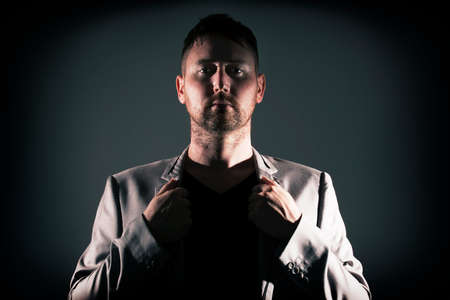 Man posing with dark background and hard lightingの写真素材