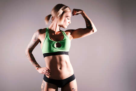 Young blonde female fitness model posing in studio. の写真素材