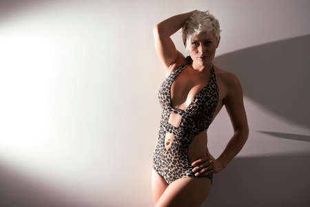 Young blonde female in swimwear posing in studioの写真素材