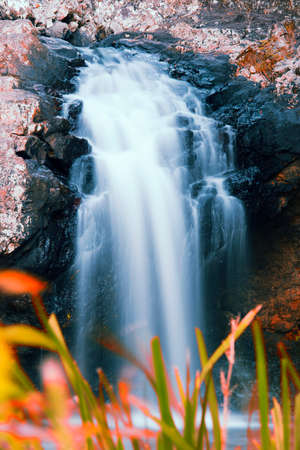 Waterfall with orange and red colours in the Gold Coast hinterlands on the Queensland and New South Wales border.の写真素材