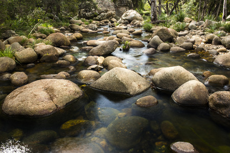 Rocks and flowing water in a creek bed at the base of the mountain Spicers Gap, Queensland, Australia.の写真素材
