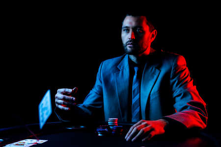 Concept: A high stakes poker player is frustrated and emotional over loosing and finding it hard to contain his emotions. Cinematic portrait.の写真素材