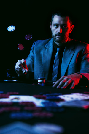 Concept: A high stakes poker player is frustrated and emotional over loosing and finding it hard to contain his emotions. Cinematic portrait.の写真素材