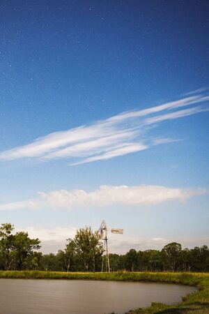 Windmill at night with shining stars in the countryside near Mount Walker, Queensland, Australia.の写真素材
