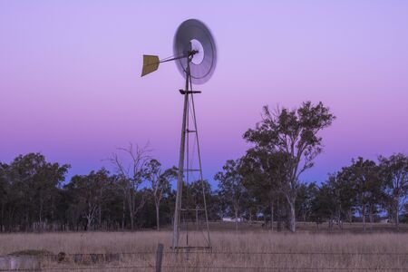 Windmill in a paddock in the late afternoon