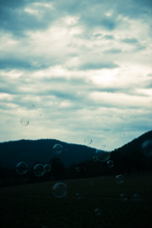Bubbles floating in the outside amongst a country field.