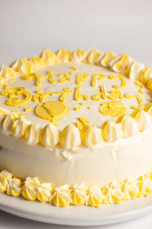 Lemon flavoured Happy Birthday Sponge cake with yellow decorative icing.