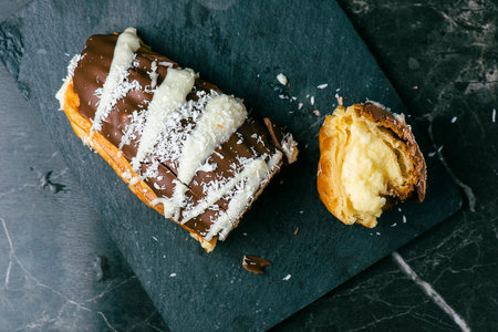 Home-made Eclair with mango and coconut whipped cream. Dipped in milk chocolate.