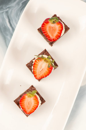 Deliciously rich cake brownie slice with Chantilly cream and fresh strawberry.の写真素材