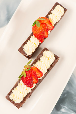 Deliciously rich cake brownie slice with Chantilly cream and fresh strawberry.の写真素材