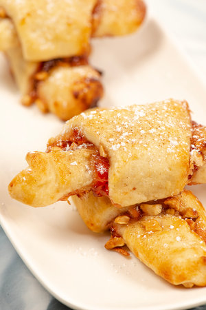 Rugelach cookies made on a cream cheese dough with strawberry jam, mixed nuts topped with cinnamon sugar.の写真素材