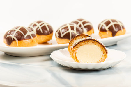 Six pack of gluten free profiteroles covered in milk and white chocolate and filled with fresh...