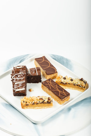Selection of gourmet gluten free sweets including macadamia crumble, caramel and brownie slices.の写真素材