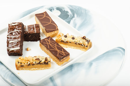 Selection of gourmet gluten free sweets including macadamia crumble, caramel and brownie slices.の写真素材