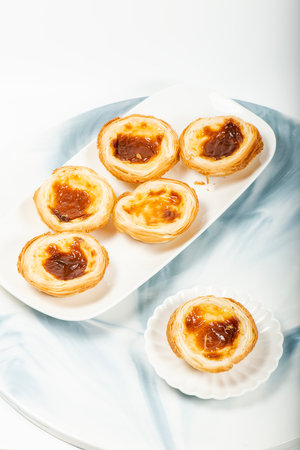 Delectable golden baked and flakey Portuguese custard tartsの写真素材