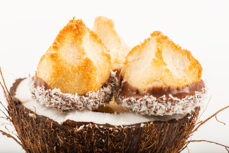 Fresh homemade delicious coconut macaroons dipped in milk chocolate and shredded coconut.の写真素材
