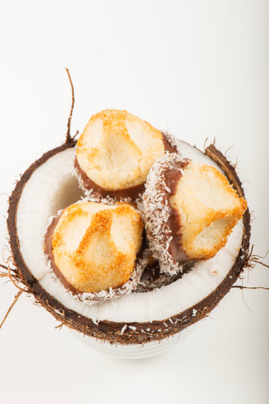 Fresh homemade delicious coconut macaroons dipped in milk chocolate and shredded coconut.の写真素材