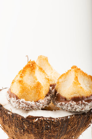 Fresh homemade delicious coconut macaroons dipped in milk chocolate and shredded coconut.の写真素材