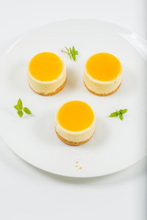Creamy petite mango cheesecake with mango jelly and a wholewheat biscuit crumb base.の写真素材