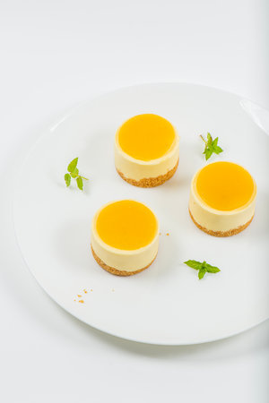 Creamy petite mango cheesecake with mango jelly and a wholewheat biscuit crumb base.の写真素材