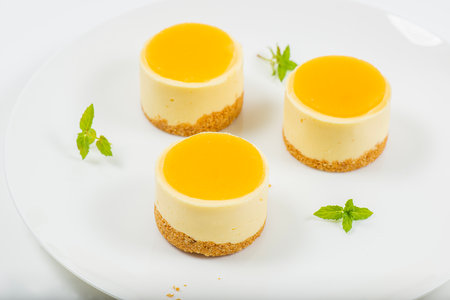 Creamy petite mango cheesecake with mango jelly and a wholewheat biscuit crumb base.の写真素材