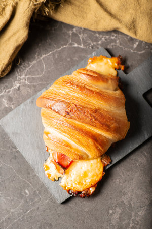 Flavoursome gold brown baked champagne ham and sliced cheese croissant.の写真素材