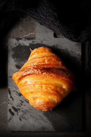 Delicious golden brown baked crispy and flaky plain buttery croissant.の写真素材