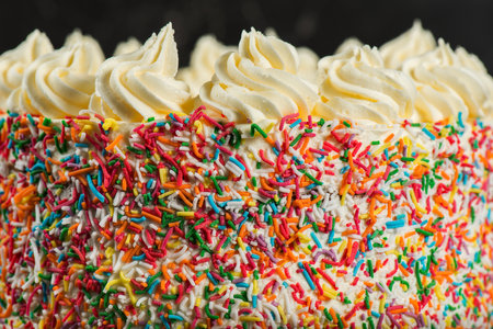 Delicious birthday-themed butter cake with buttercream icing and rainbow sprinklesの写真素材