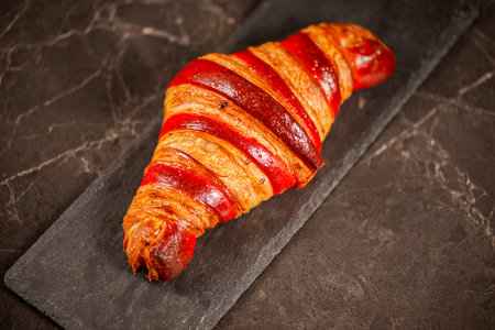 Detailed close-up of crispy, flaky, and delicious hand-laminated bicolour chilli-flavoured croissant.の写真素材