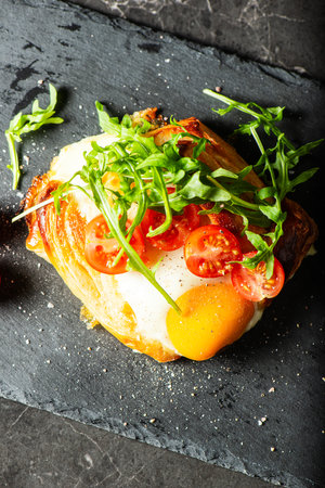 Homemade savoury breakfast Danish with a free-range egg, cherry tomatoes and fresh rocket.の写真素材