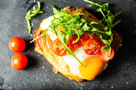 Homemade savoury breakfast Danish with a free-range egg, cherry tomatoes and fresh rocket.の写真素材